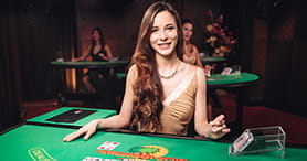 Ein weiblicher Dealer beim Blackjack im Euro Palace Live Bereich. Im Hintergrund spielen zwei weitere Dealerinnen.