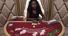 Ein weiblicher Croupier am Blackjack Tisch im Gate 777 Casino bei der Ausgabe der Karten im Spiel. 