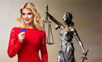 Eine Live Dealerin und eine Statue von Justitia.
