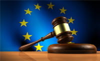 Ein Richterhammer und eine EU-Flagge im Hintergrund..