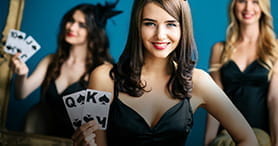 Ein weiblicher Croupier am Blackjack Tisch im SCasino bei der Ausgabe der Karten im Spiel.