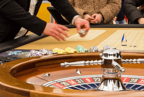 Das Bild zeigt Spieler, die am Roulette Tisch ihren Einsatz auf das Setzfeld legen