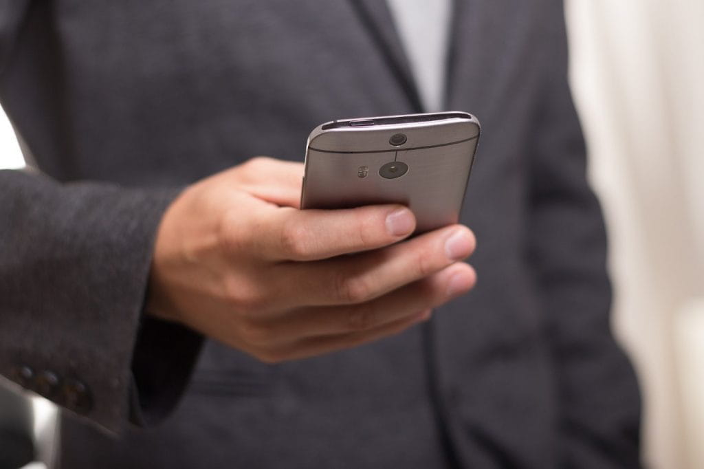 Ein Mann hält ein Smartphone in der Hand.