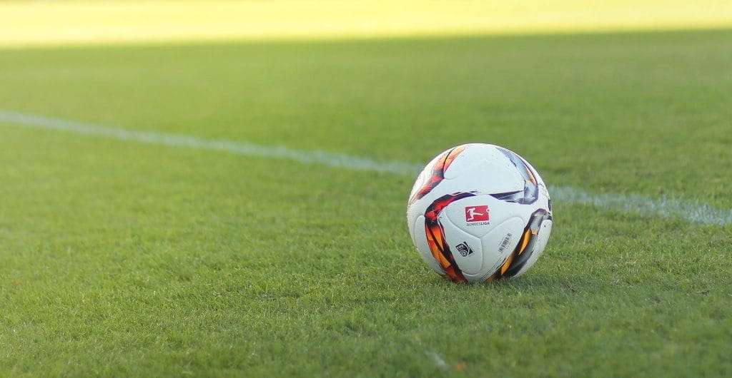 Ball mit Bundesligalogo auf Fußballplatz.