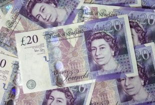 Mehrere 20 britische Pfund Geldscheine liegen ungeordnet übereinander.