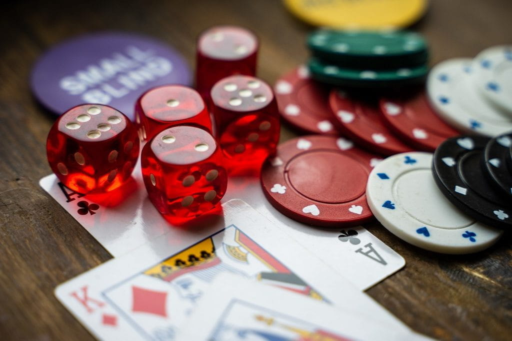 Spielkarten, Pokerchips und Würfel auf einem Tisch.