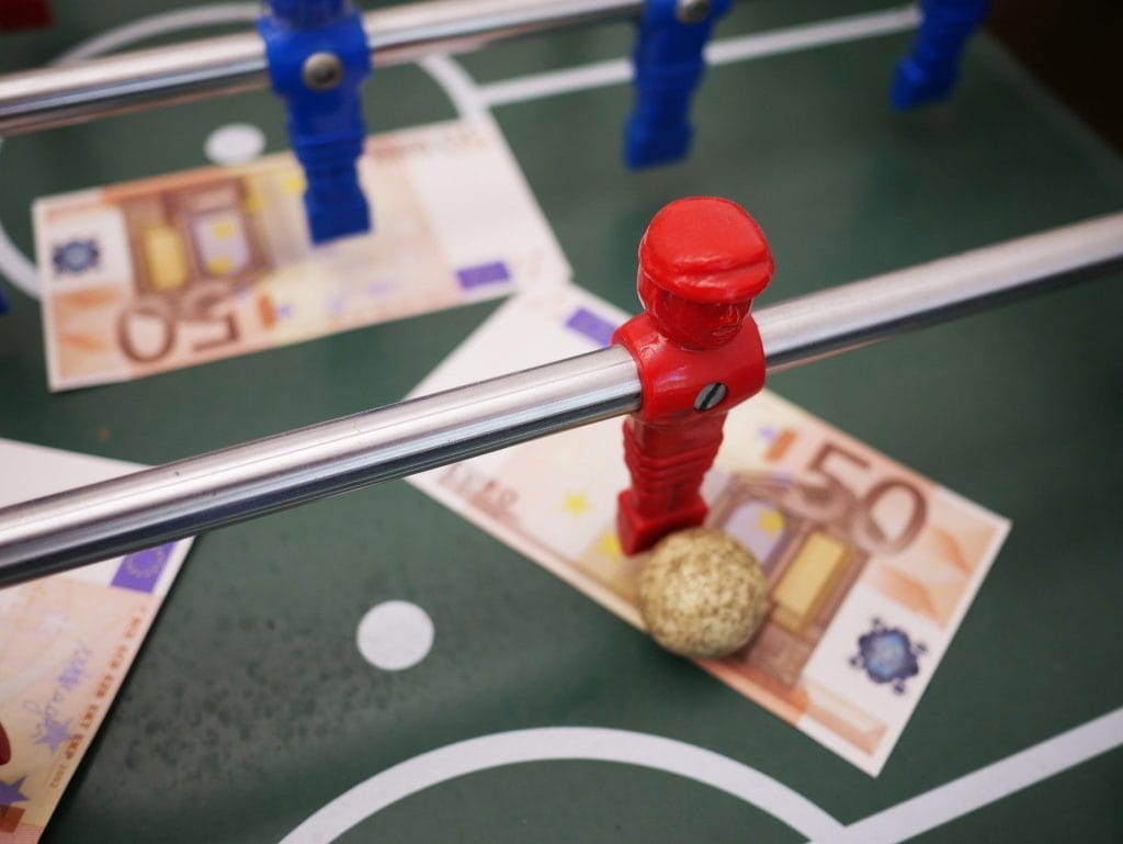 Ein Tischfußballfeld inklusive einiger Spieler auf dem mehrere 50-Euro-Scheine liegen.