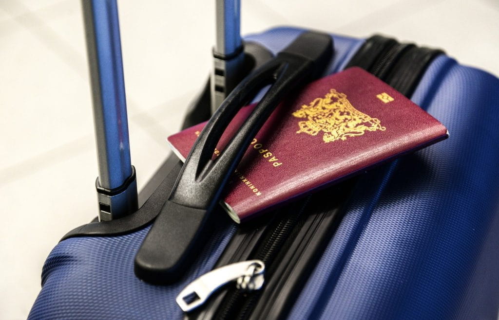 Ein blauer Reisekoffer, auf dem ein Reisepass liegt.