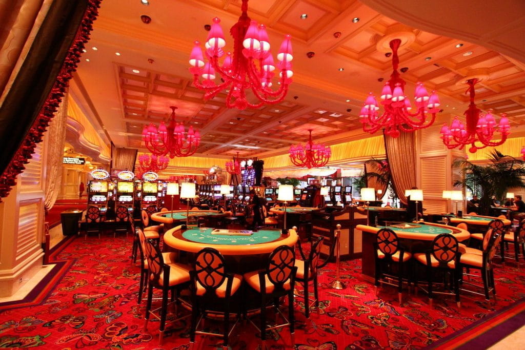 Das Innere des Wynn Casino; Blackjack-Tische und Spielautomaten im glitzernden bunten Licht.