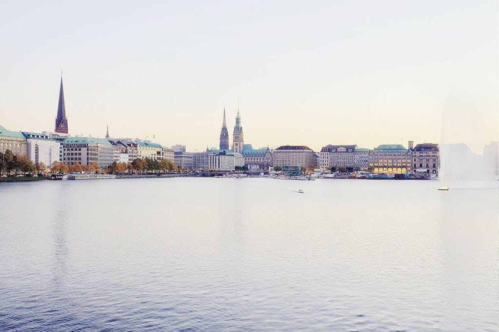 Panorama der Hansestadt Hamburg vor der Alster bei Tag unter bewölktem Himmel.