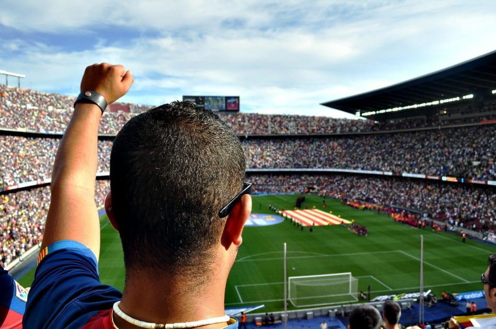 Fan des FC Barcelona jubelnd in einem vollen Fußballstadion eines La-Liga-Spiels.