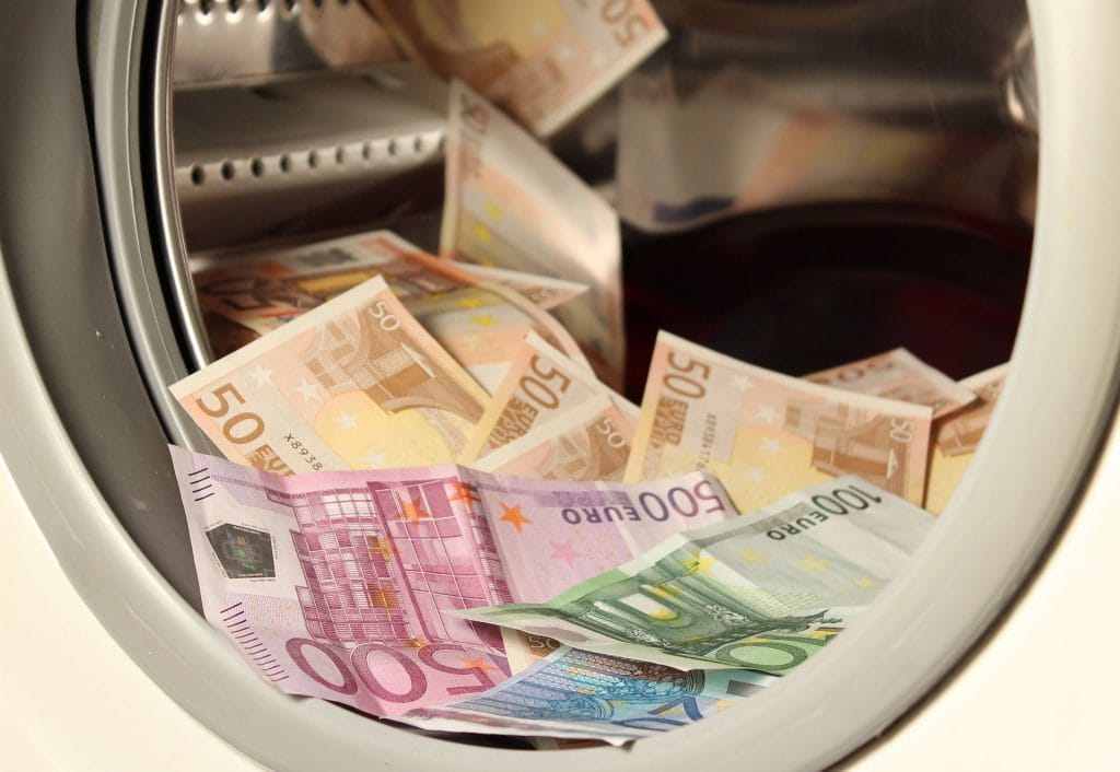 Verschiedene Euro-Geldscheine zusammengeworfen in einer Wäschetrommel.