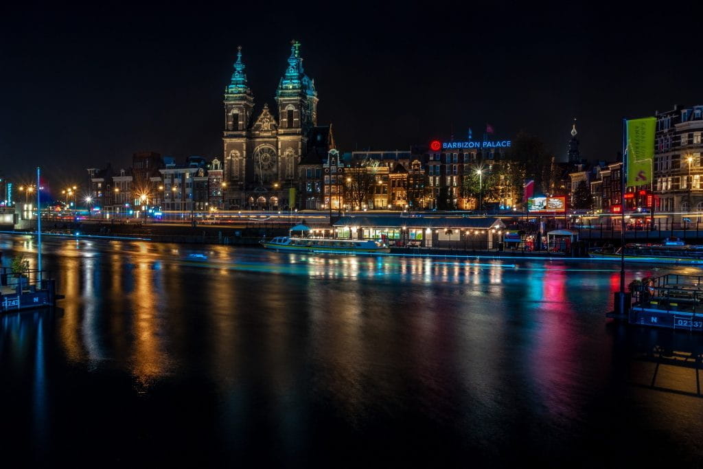 Die Basilika St. Nikolaus in Amsterdam bei Nacht vom gegenüberliegenden Ufer.