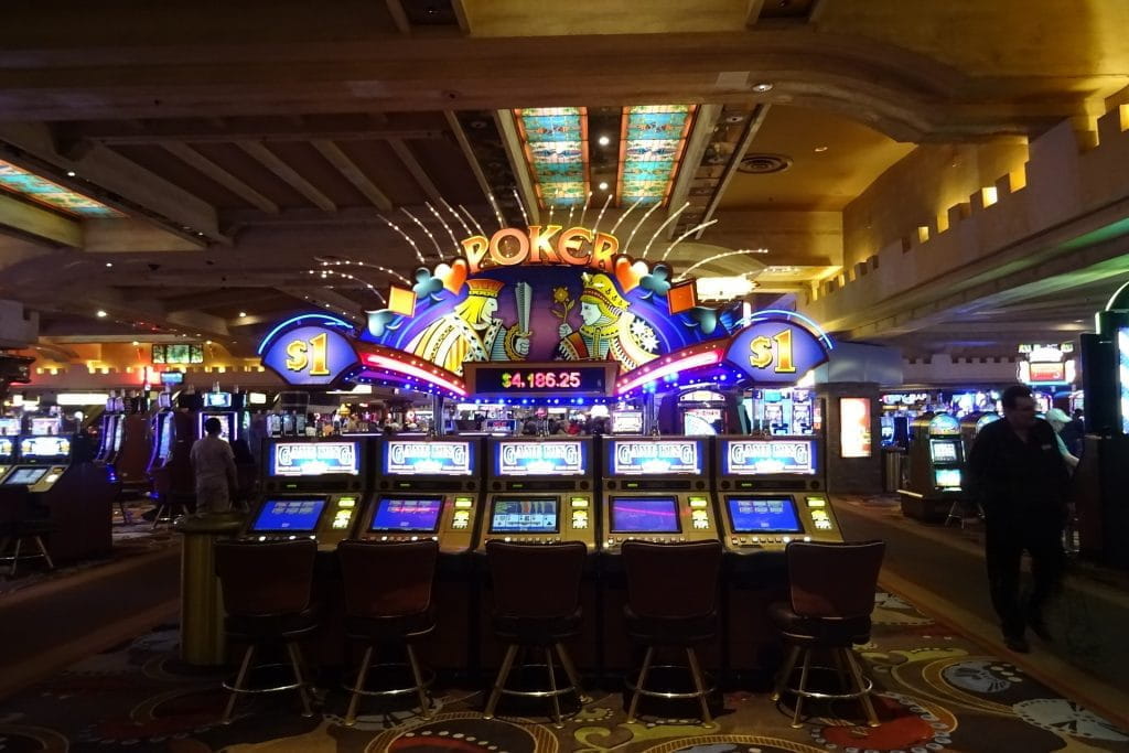 Ein Saal voller Spielautomaten in einem Casino.