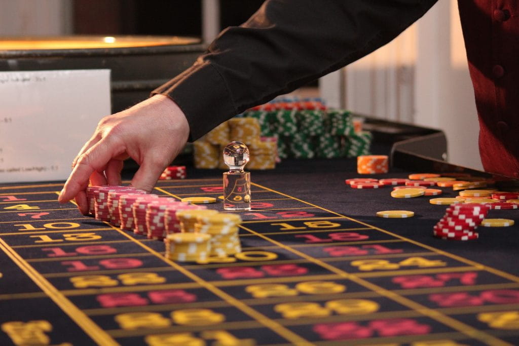 Ein Croupier platziert Jetons auf einem Roulette-Tisch.