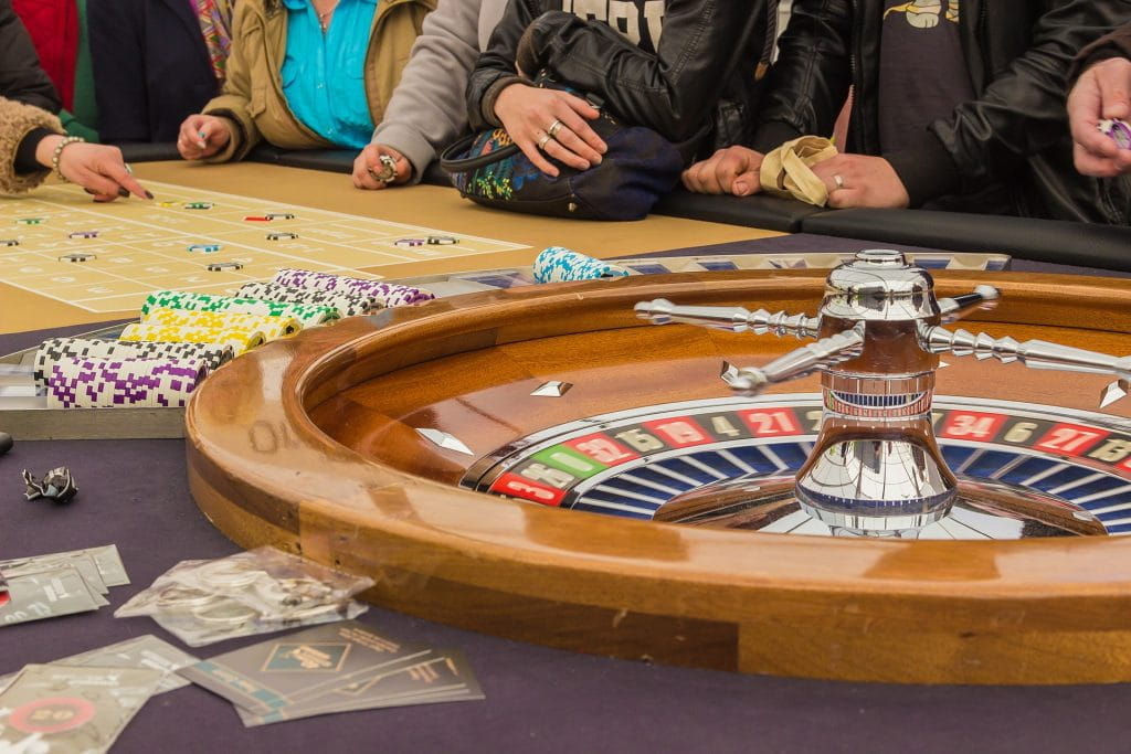 Menschen spielen an einem Roulette-Tisch.