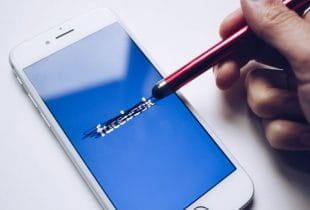 Durchgestrichener Facebook-Schriftzug auf einem Smartphone-Display.