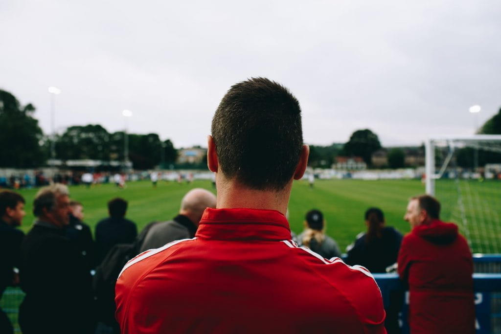 Ein Mann schaut sich Fußballspiel an.
