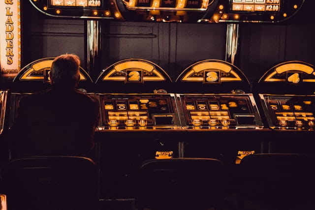 Ein Mann zockt an einem Spielautomat in einem Casino.