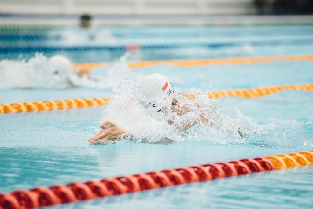 Mehrere Schwimmer ziehen Bahnen in einem Schwimmbecken.