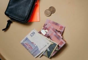 Ein Portemonnaie und Britische Pfund auf einem Tisch.