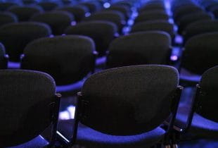 Mehrere Stuhlreihen in einem Messesaal.