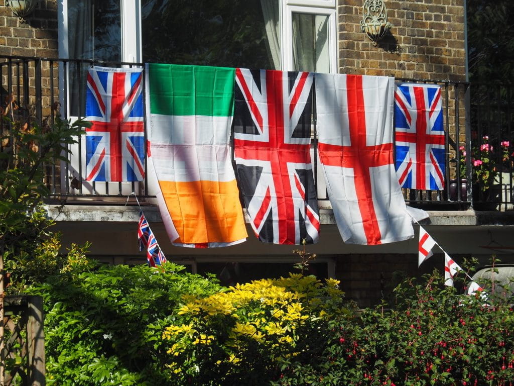 Die Flaggen von Irland, England und Großbritannien hängen an einer Balkonbalustrade.