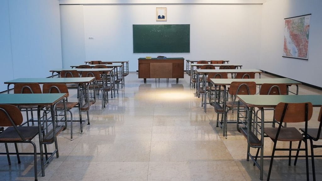 Ein leerer Klassenraum mit Schulbänken.