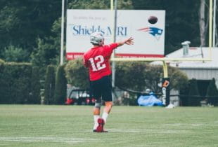 Tom Brady wirft einen Football während des Trainings.