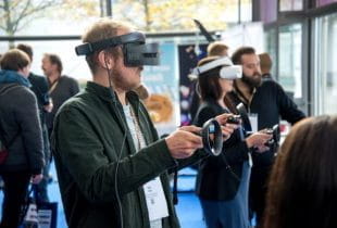 Ein Mann mit einer VR-Brille und Steuerpads.