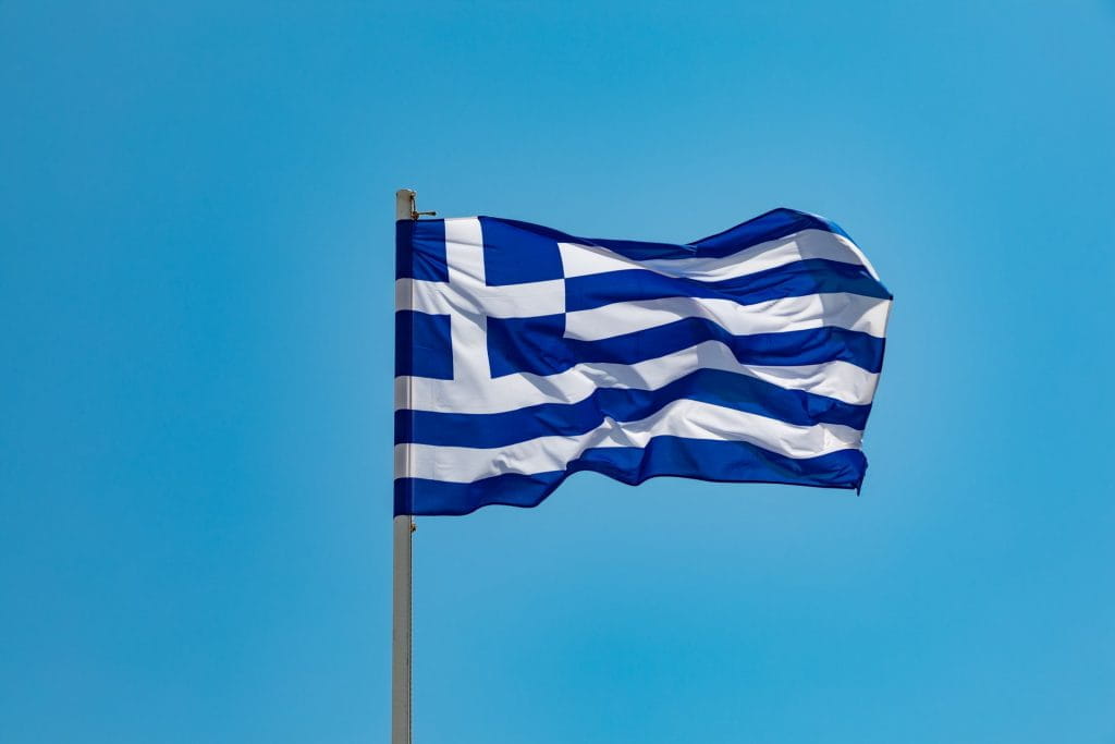 Griechische Flagge an einem Fahnenmast weht im Wind.