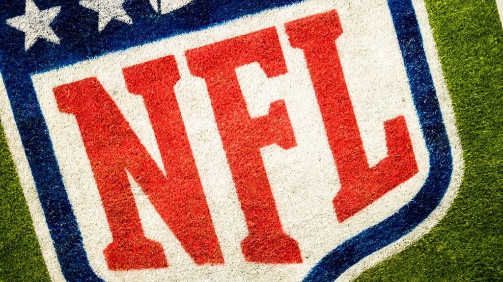 Das Logo der National Football League auf grünem Rasen.