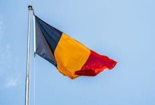 Die belgische Flagge an einem Fahnenmast.