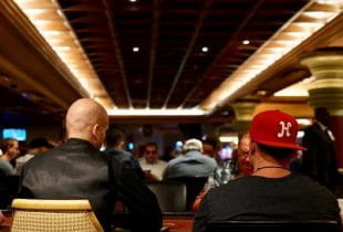 Mehrere Spieler an Pokertischen während eines Turniers.