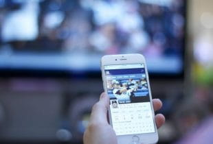 Eine Person hält ein Smartphone mit Infos über die MLB in der Hand.