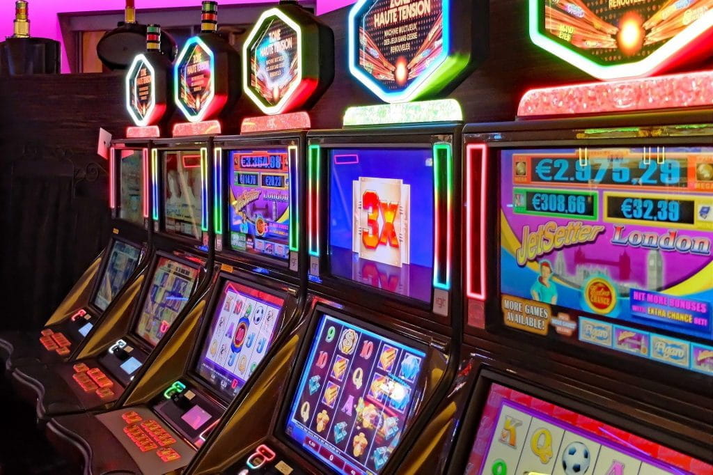 Vier aneinandergereihte Spielautomaten in einem Casino.
