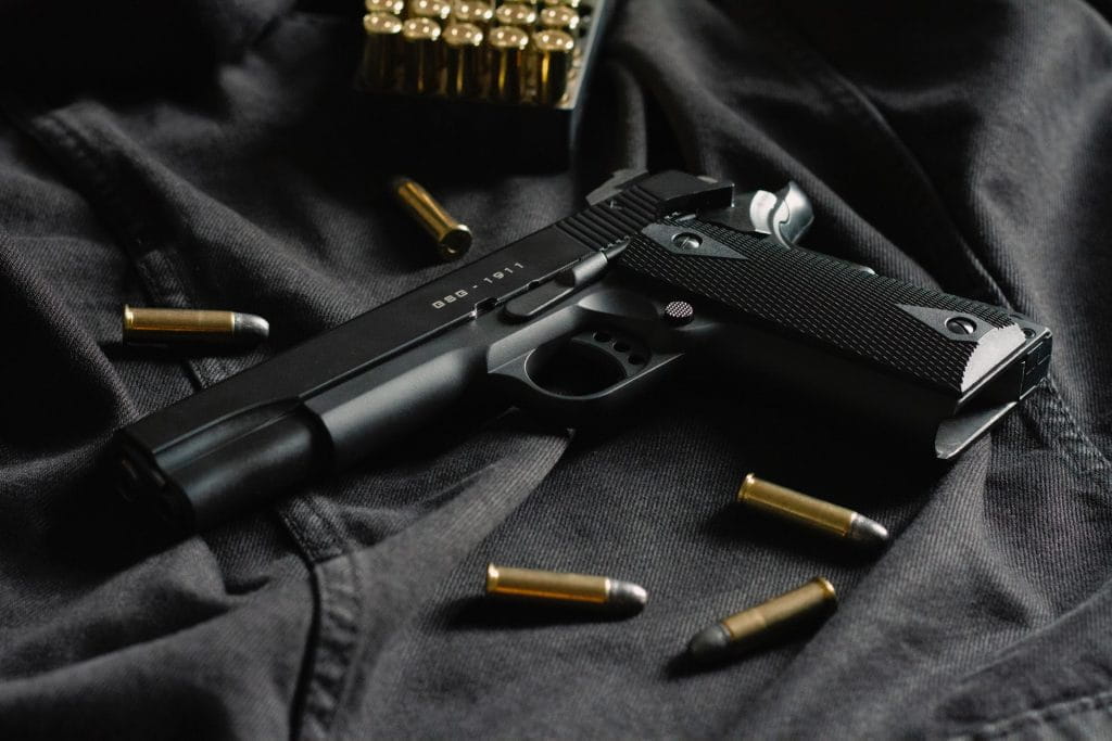 Eine schwarze Pistole umringt mit Munition.