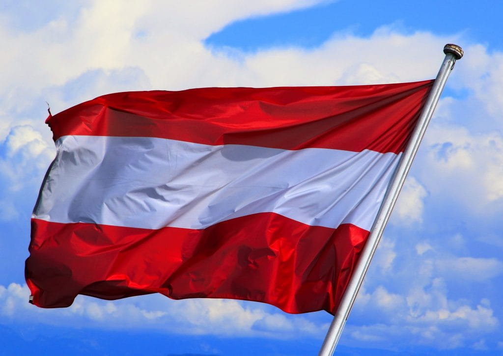 Die Flagge Österreichs an einem Fahnenmast weht im Wind.