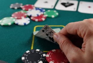 Ein Pokerspieler schaut sich sein Blatt mit zwei Königen an.