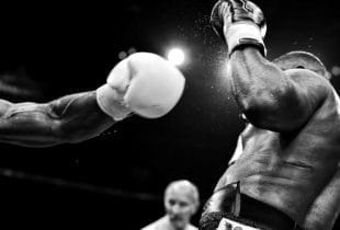 Ein Boxer wird während eines Kampfes hart von seinem Konkurrenten getroffen.