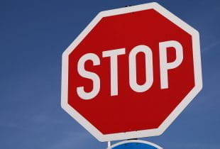 Ein Stoppschild vor blauem Himmel.