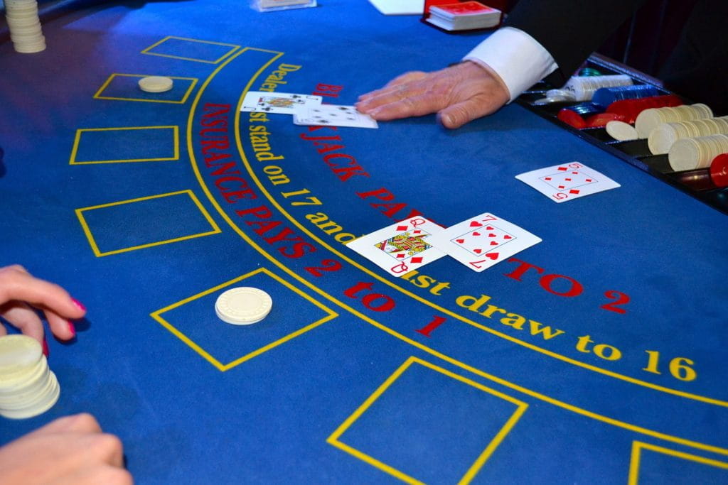 Ein Dealer verteilt Karten an einem Blackjack-Tisch.