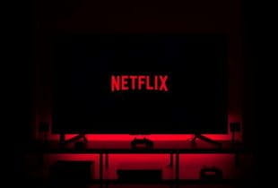 Netflix-Logo auf einem Fernseher in einem dunklen Raum.