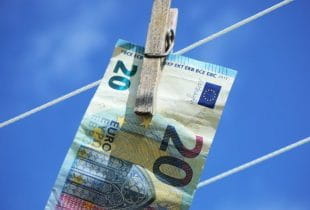 Ein 20-Euro-Schein mit Wäscheklammer hängt an einer Wäscheleine.