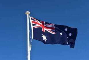 Die Nationalflagge Australiens weht an einem Fahnenmast im Wind.