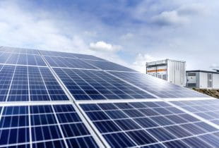 Photovoltaik-Panels mit Generatoren im Hintergrund.