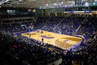 Eine Partie im College-Basketball in großer Sporthalle.