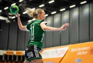 Eine Handballspielerin mit einem Ball in der Hand holt zum Wurf aus.