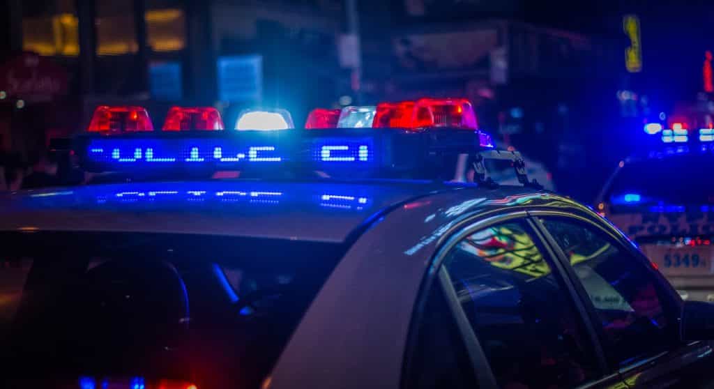 Mehrere Polizeiautos mit Blaulicht während einer Razzia.