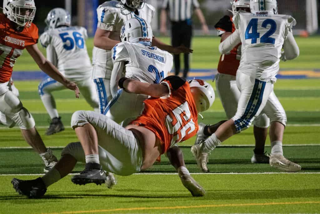 Ein Defender tackelt einen Quarterback während eines College-Footballspiels